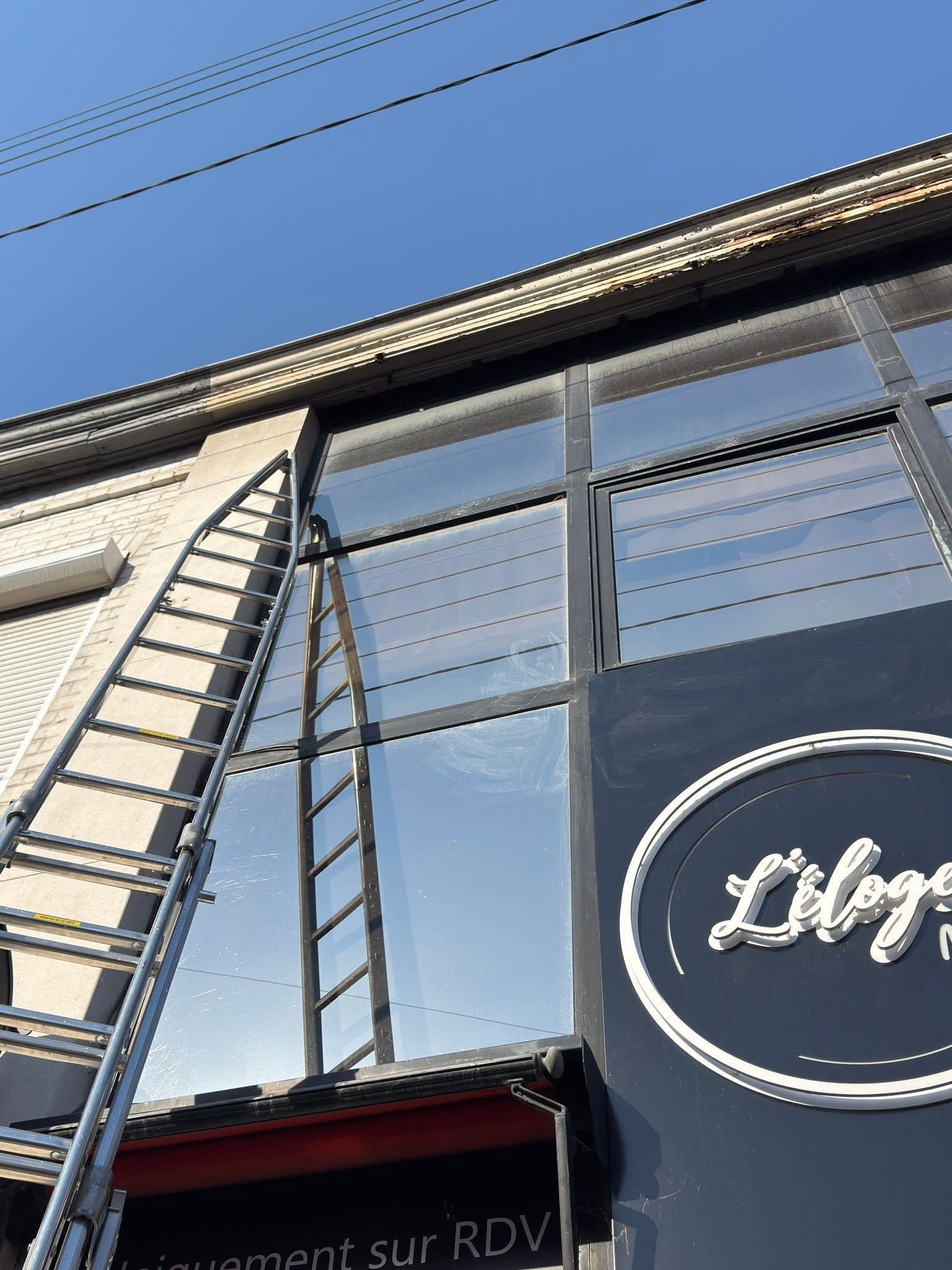 Enseigne et vitres en hauteur encrassées par la pollution sur un bâtiment commercial à Lys-lez-Lannoy avant nettoyage